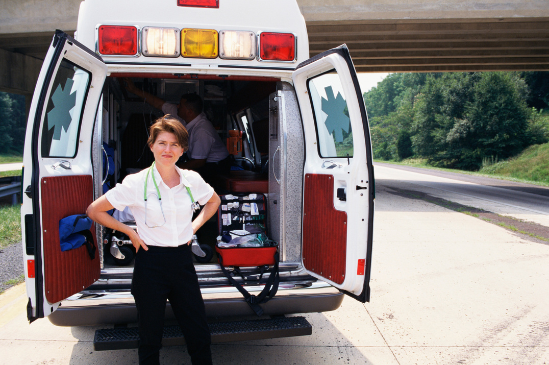 Paramedic posing by ambulance